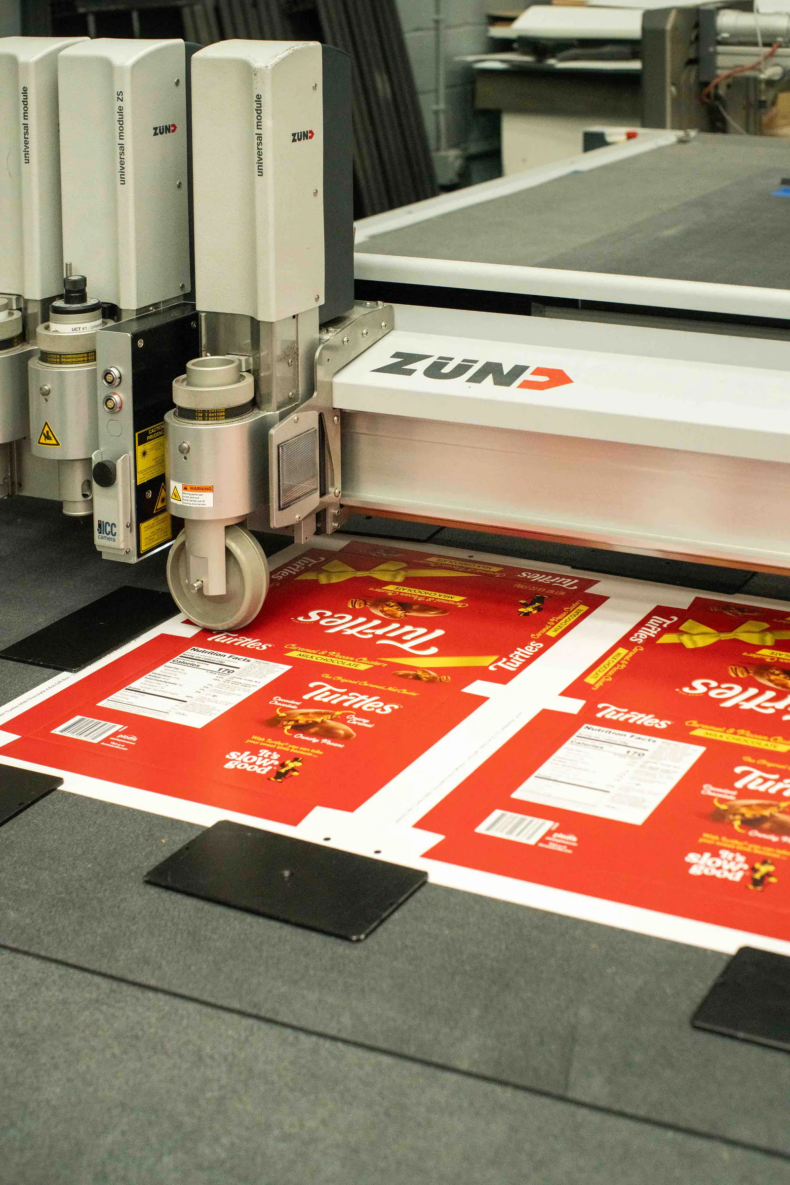 The Zünd cutter over sheets of printed Turtles boxes