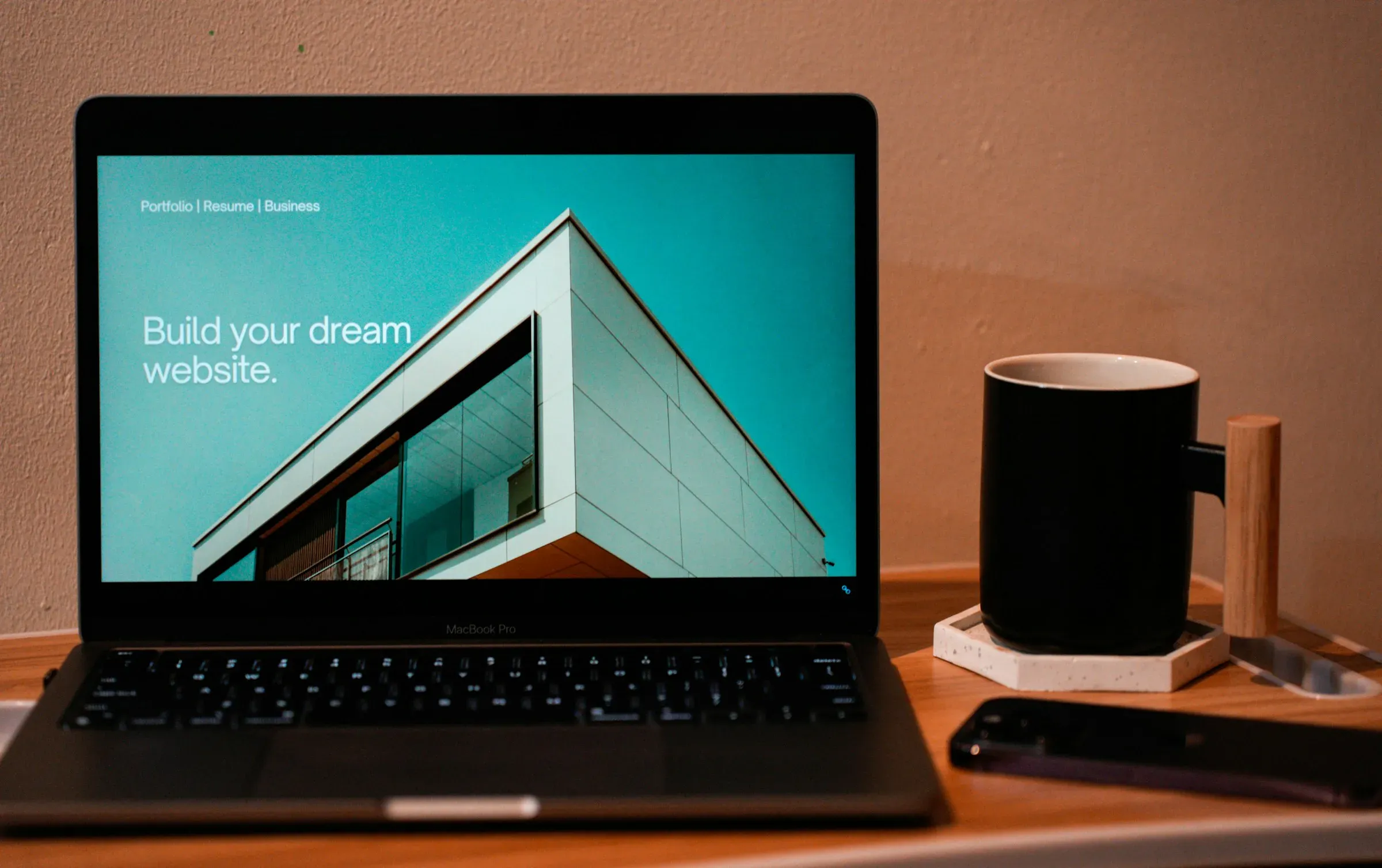 A website open on a laptop, on a wooden desk